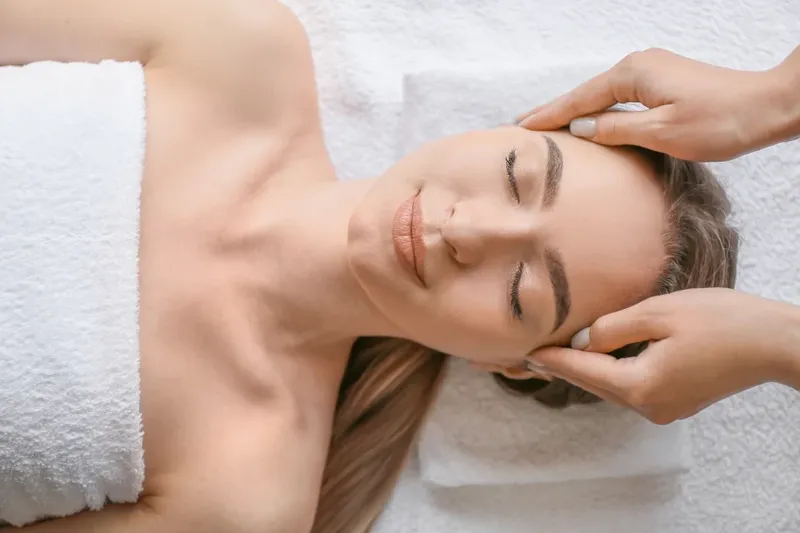 A therapist giving a relaxing facial treatment